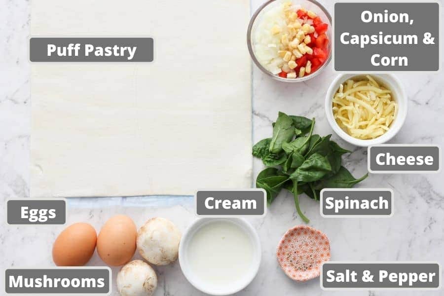 mini quiche ingredients on a marble background, like puff pastry, eggs and cream.