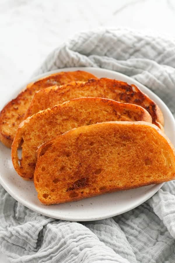 slices of cheese toast on a white plate.