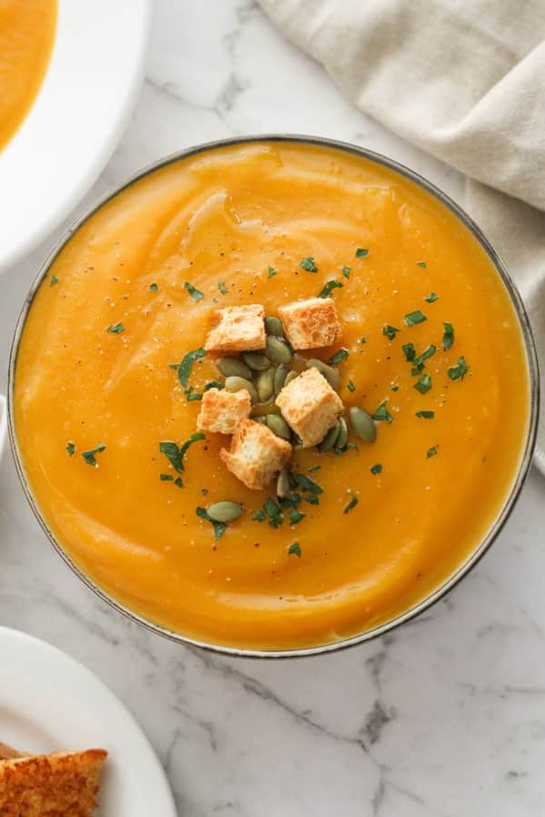 pumpkin soup topped with croutons and pumpkin seeds.