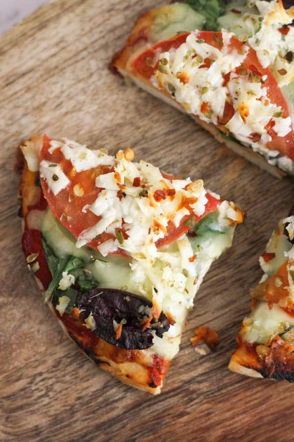 slice of pizza on a wooden serving board.