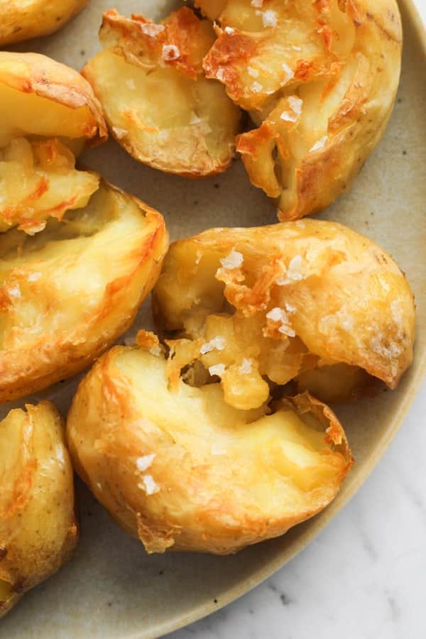 a plate of potatoes with salt flakes on top.