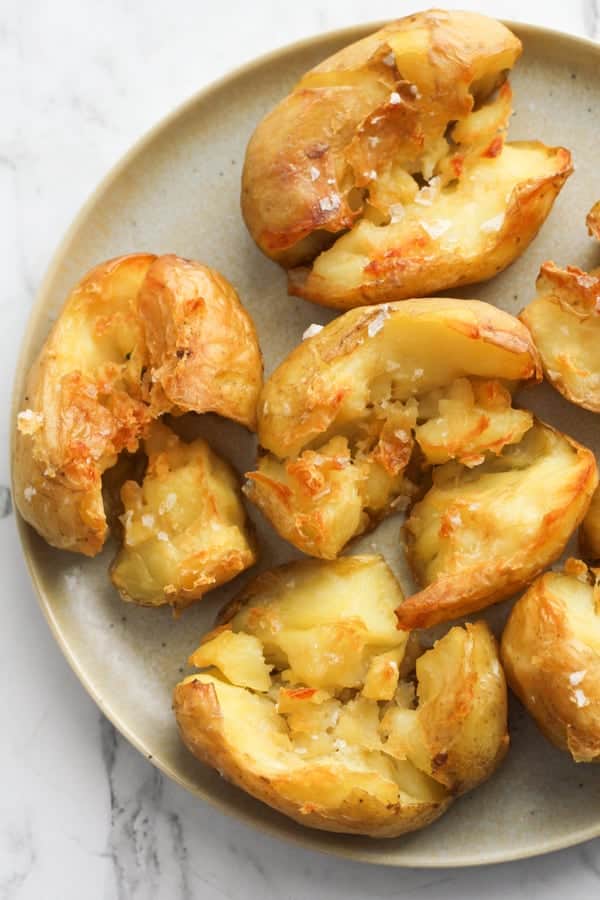 a plate of potatoes with salt flakes on top.