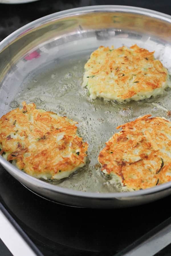 fritters cooking in a frying pan.