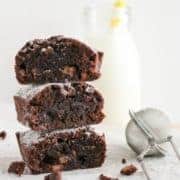 stack of brownies next to a bottle of milk.