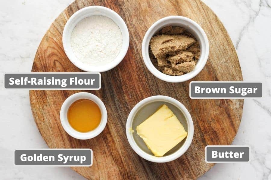 golden syrup cookies ingredients on a wooden board.