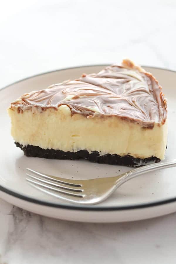 a slice of marble cheesecake with a fork on the plate.