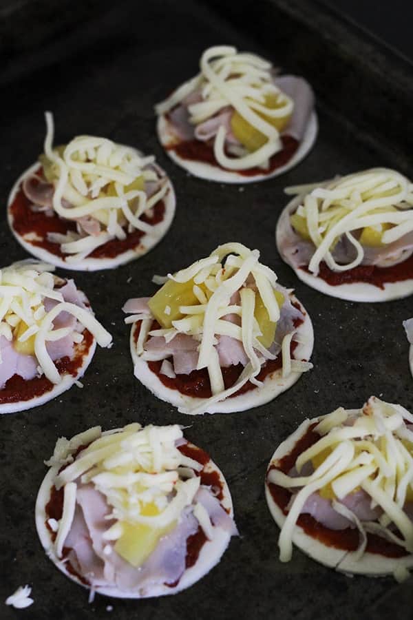 puff pastry topped with pizza toppings on a baking tray.