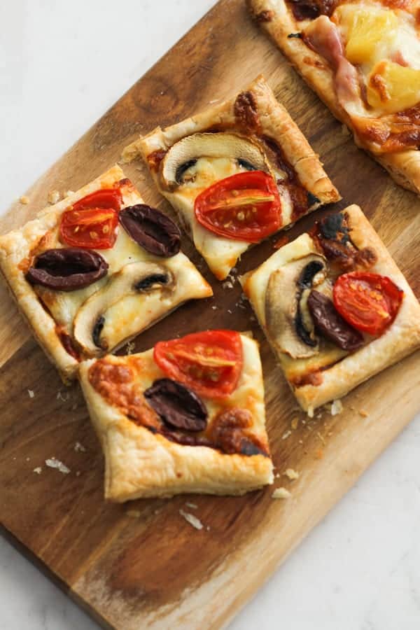 slices of pizza on a wooden serving board.