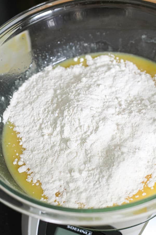 flour on top of cupcake mixture in a glass bowl.
