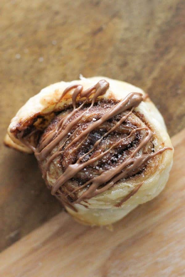 pinwheel drizzled with chocolate on a wooden board.