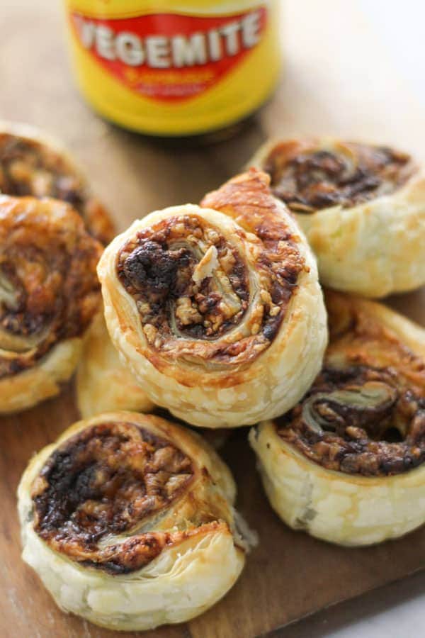 vegemite pinwheels stacked on top of each other on a wooden board.