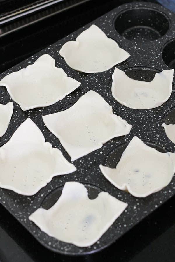 puff pastry pieces in a muffin tray.