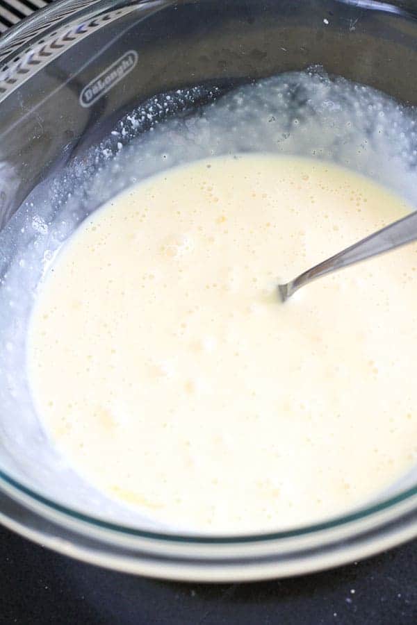 egg and cream mixed together in a glass bowl.