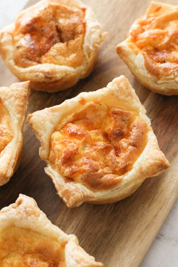 mini quiches on a wooden board.