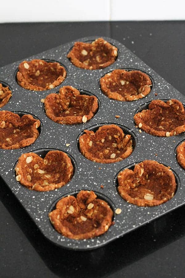 biscuits pushed into muffin tin holes to make tart cases.