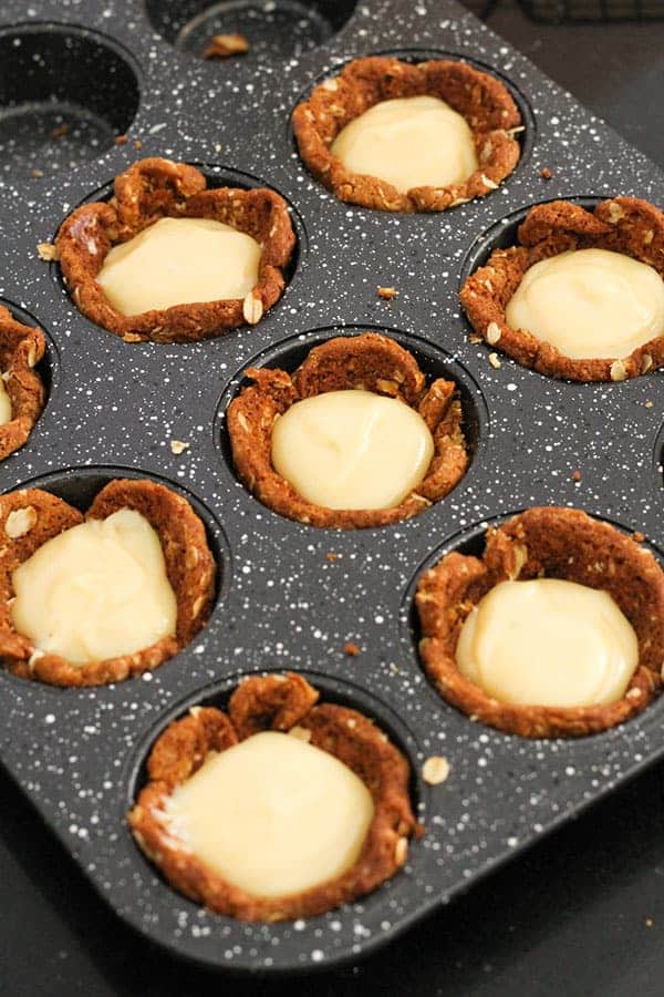 caramel filled tart cases in a muffin tray.