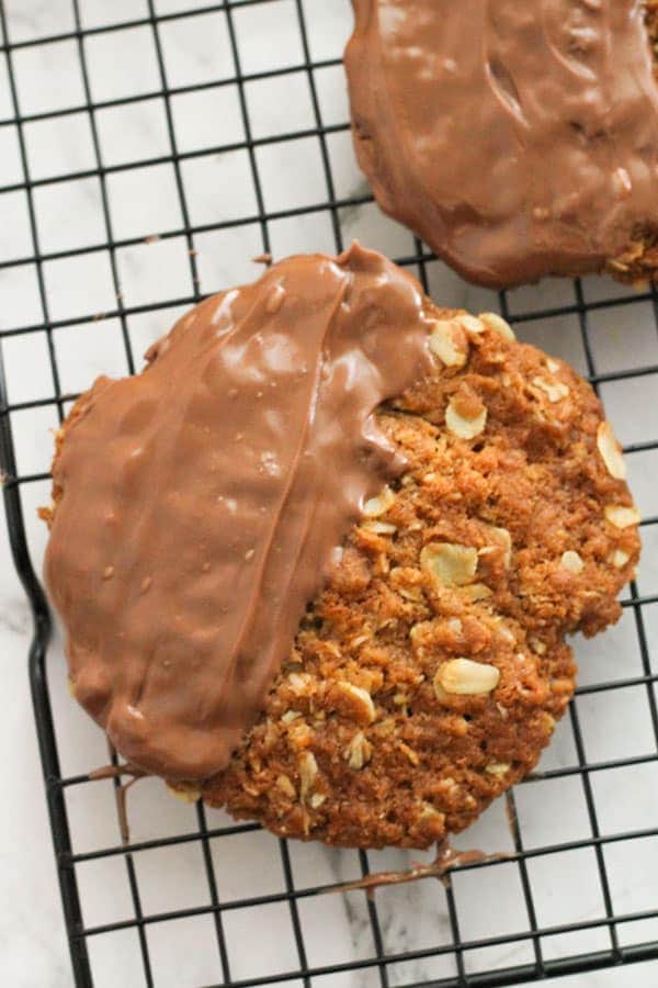 chocolate anzac biscuits on a wire rack.