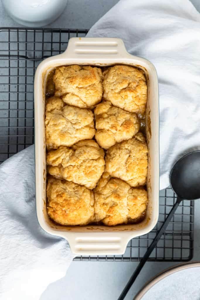 golden syrup dumplings in a baking dish on top of a wire tray.