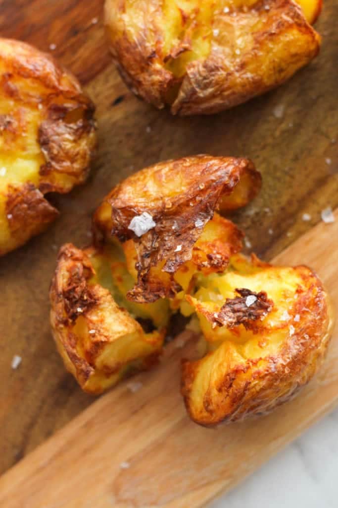 crispy smashed potatoes on a wooden board.