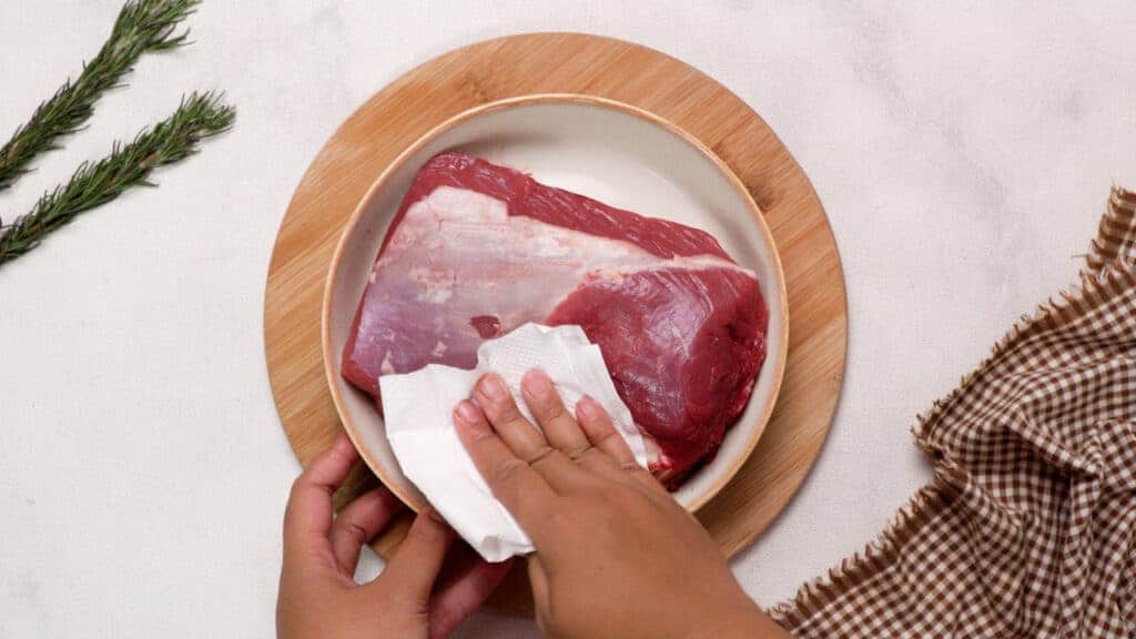 Pat drying the beef with paper towels..