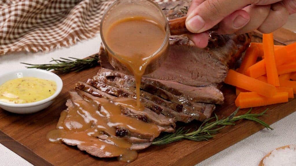 Air Fryer Roast Beef on a wooden coaster poured with gravy