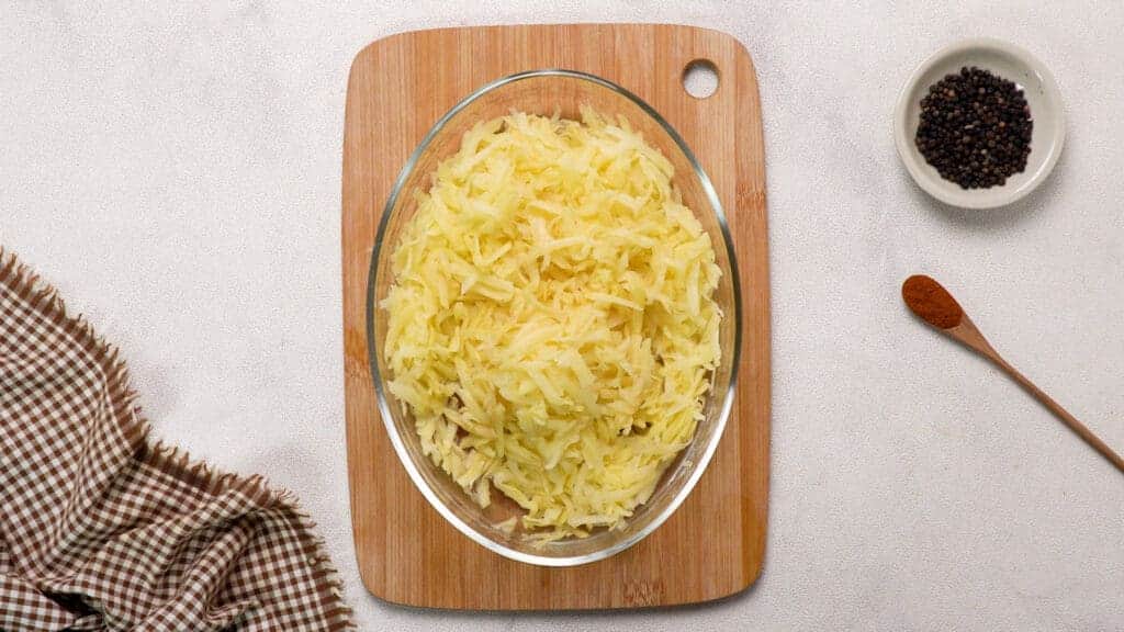 Grate potatoes in the bowl