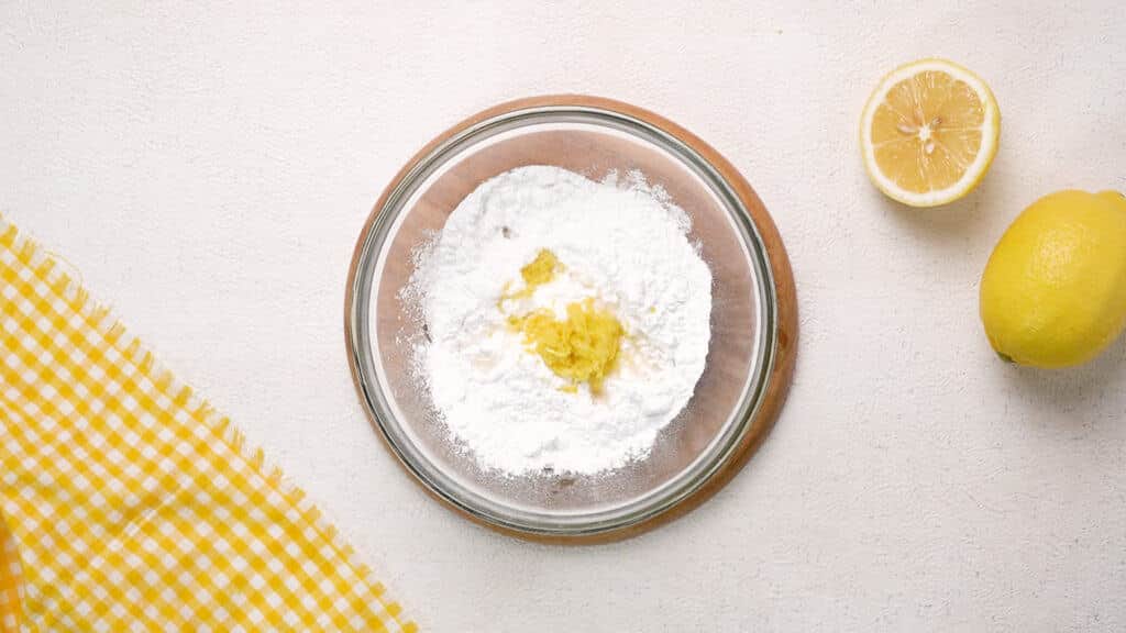 Powdered sugar, lemon juice and lemon in mixing bowl