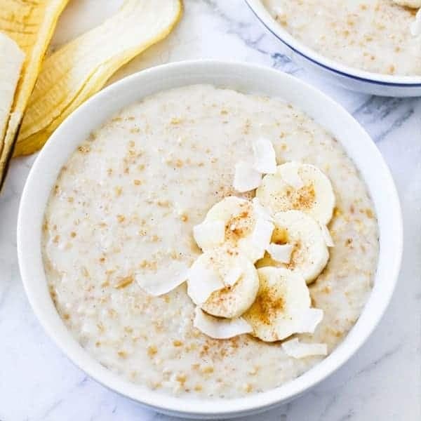 two bowls of banana maple steel cut oats topped with banana slices