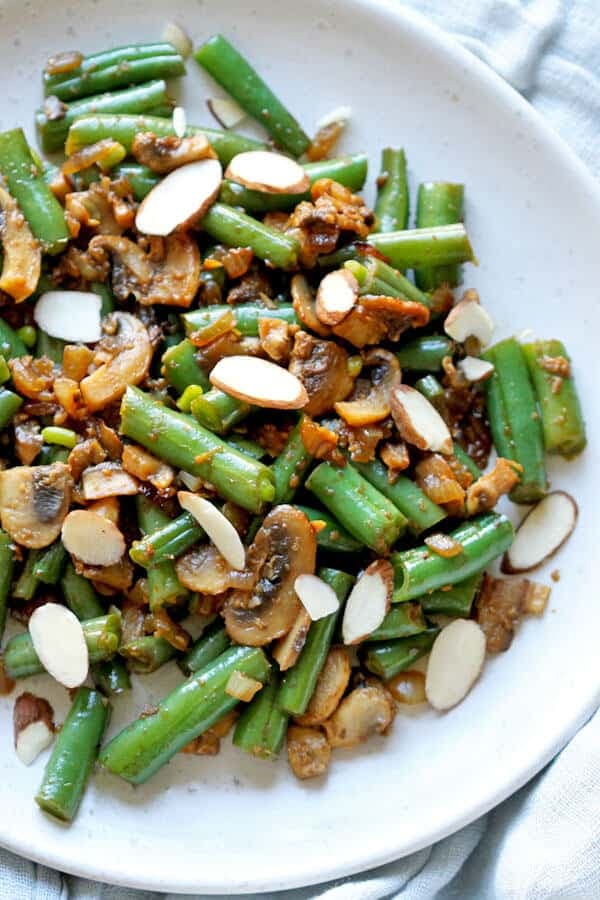 sautéed green beans and mushrooms on a white plate