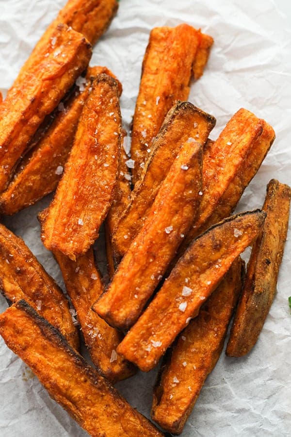 sweet potato wedges on white baking paper covered in salt.