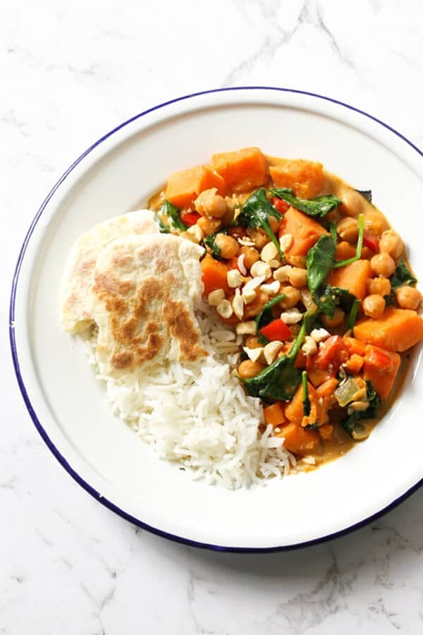 sweet potato, chickpea and spinach curry in a bowl with rice