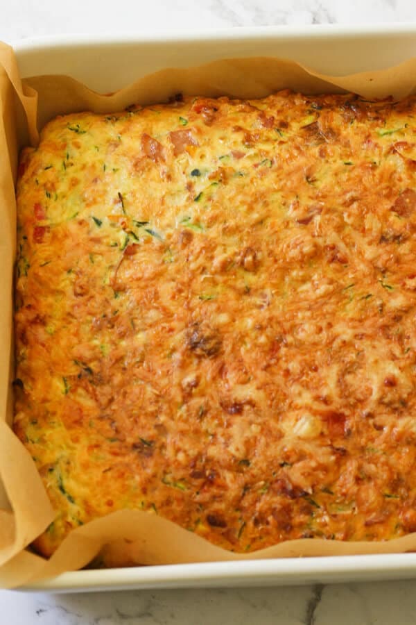 Zucchini and Bacon Slice in a baking tray just out of the oven. 