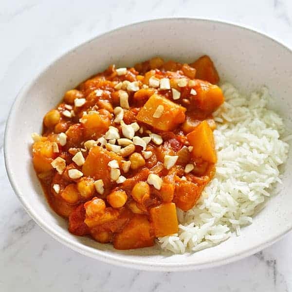 a white bowl filled with pumpkin chickpea curry and rice