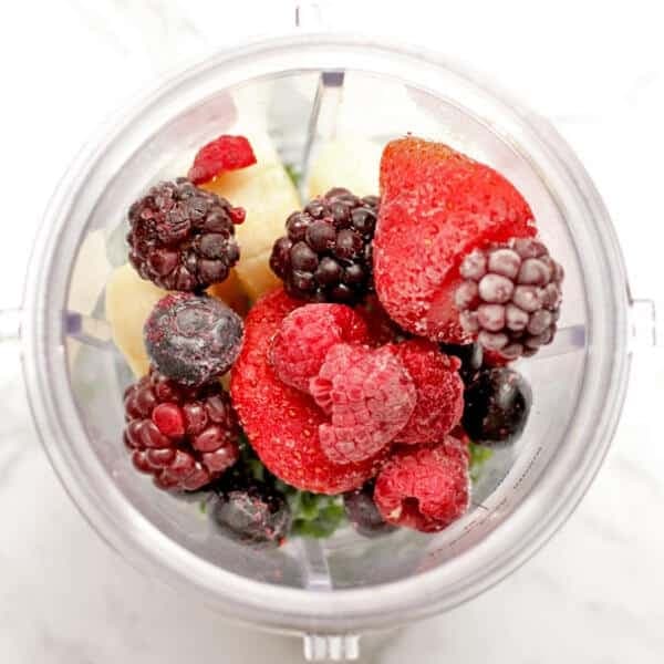 berry smoothie ingredients in a blender cup