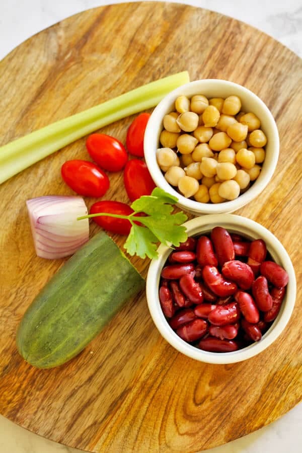 middle eastern bean salad ingredients on a chopping board