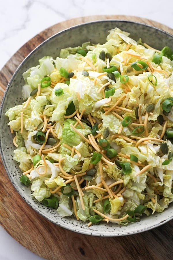 salad in a large bowl on top of a wooden board.