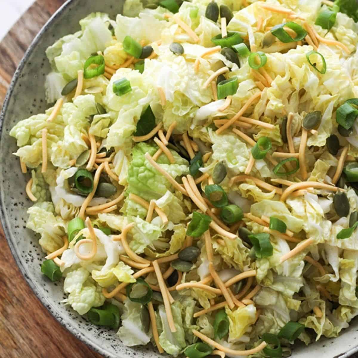 cabbage and crunchy noodle salad in a large grey bowl.