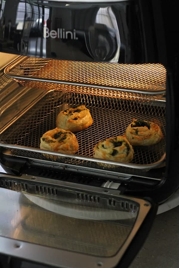 spinach and feta pinwheels cooking in the air fryer.