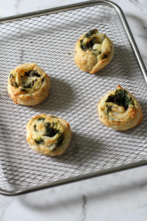 spinach and feta pinwheels on an air fryer tray.