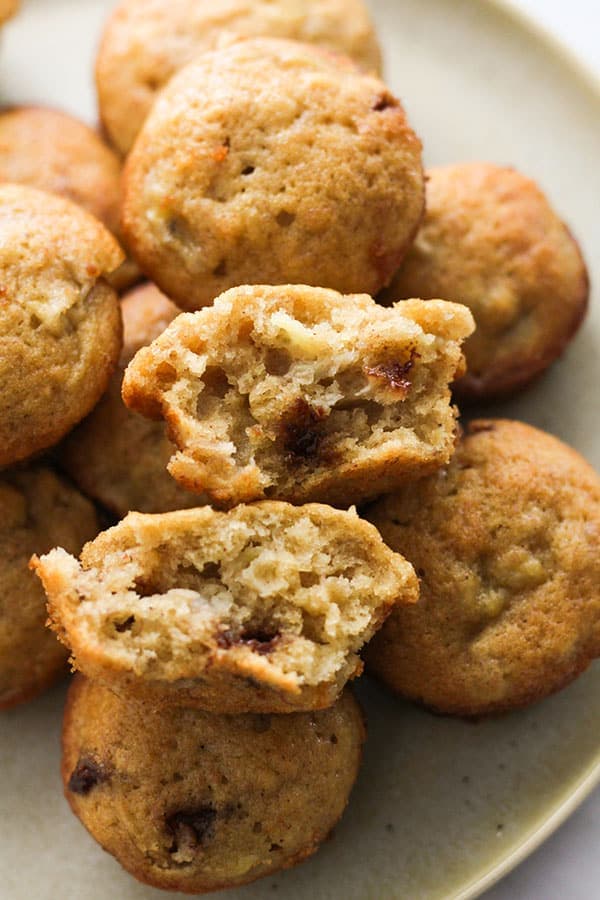 mini banana muffins stacked on a plate.