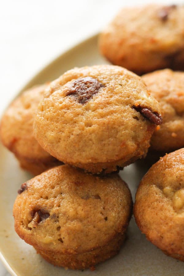 mini banana muffins stacked on a plate.