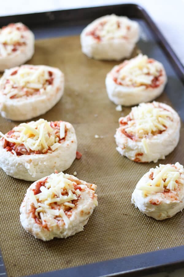 ham and cheese scrolls on a baking tray ready for the oven.