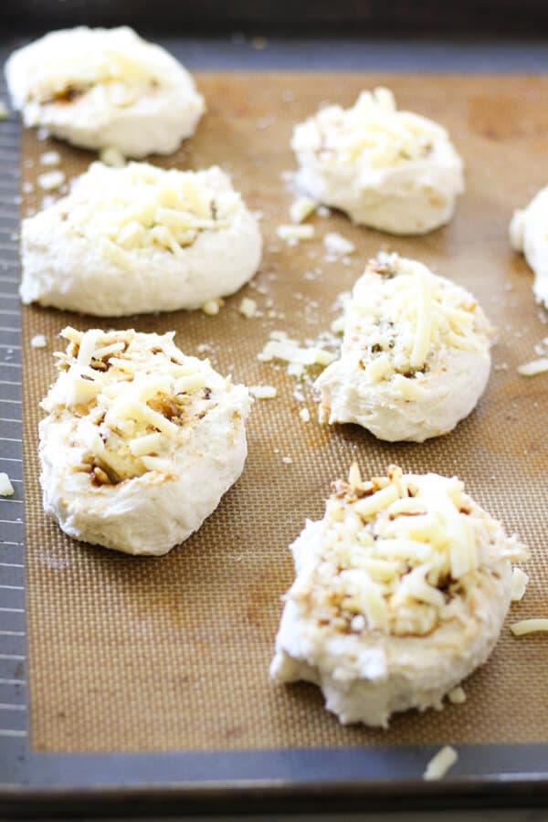 cheese and vegemite scrolls on a baking tray ready for the oven.