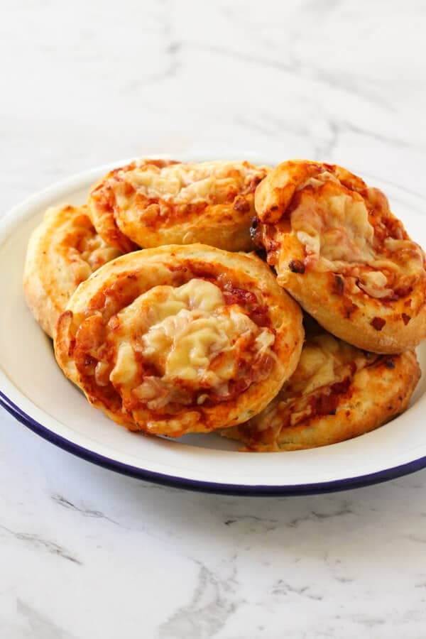 a plate of ham and cheese scrolls.