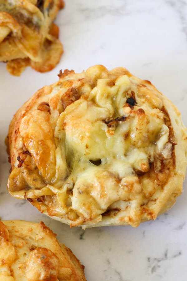 cheese and vegemite scrolls lying on a marble board.
