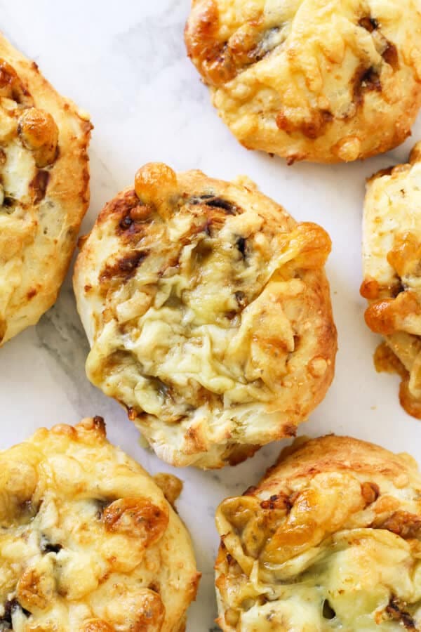 cheese and vegemite scrolls lying on a marble board.