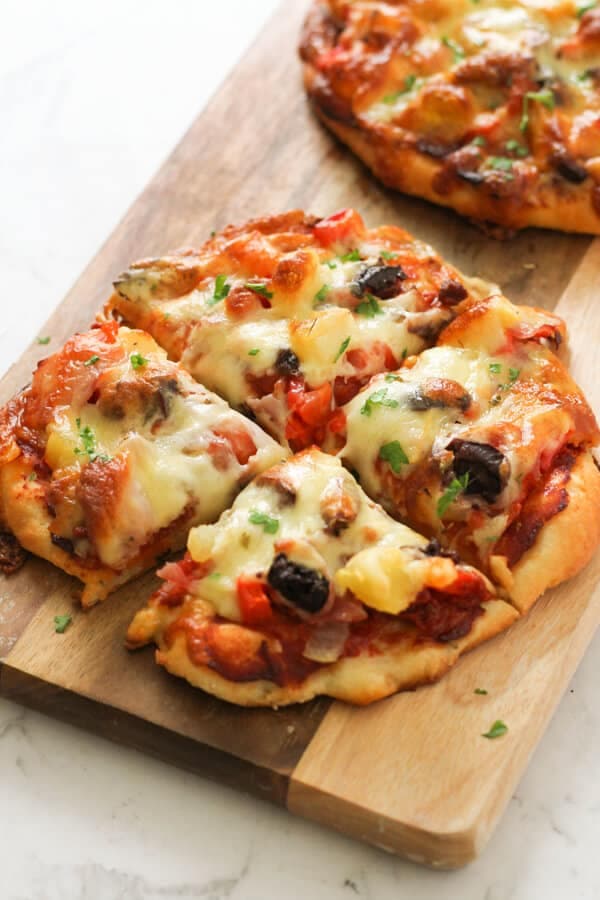 Supreme Pizza on a wooden cutting board.