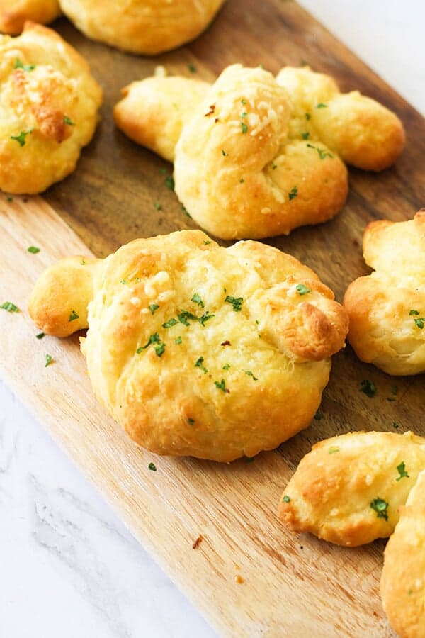 garlic knots on a wooden serving board.
