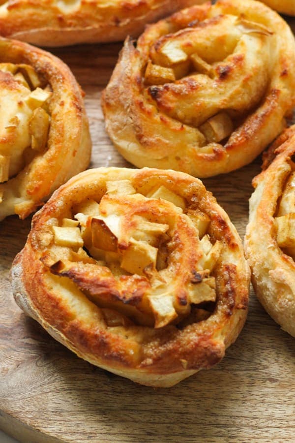 apple cinnamon rolls on a wooden board.