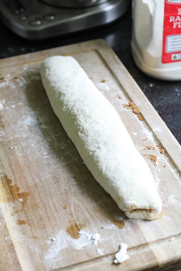 dough rolled into a log on top of a wooden board